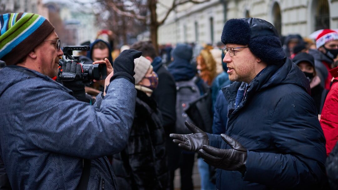 Journalist with microphone interviewing a person outdoors